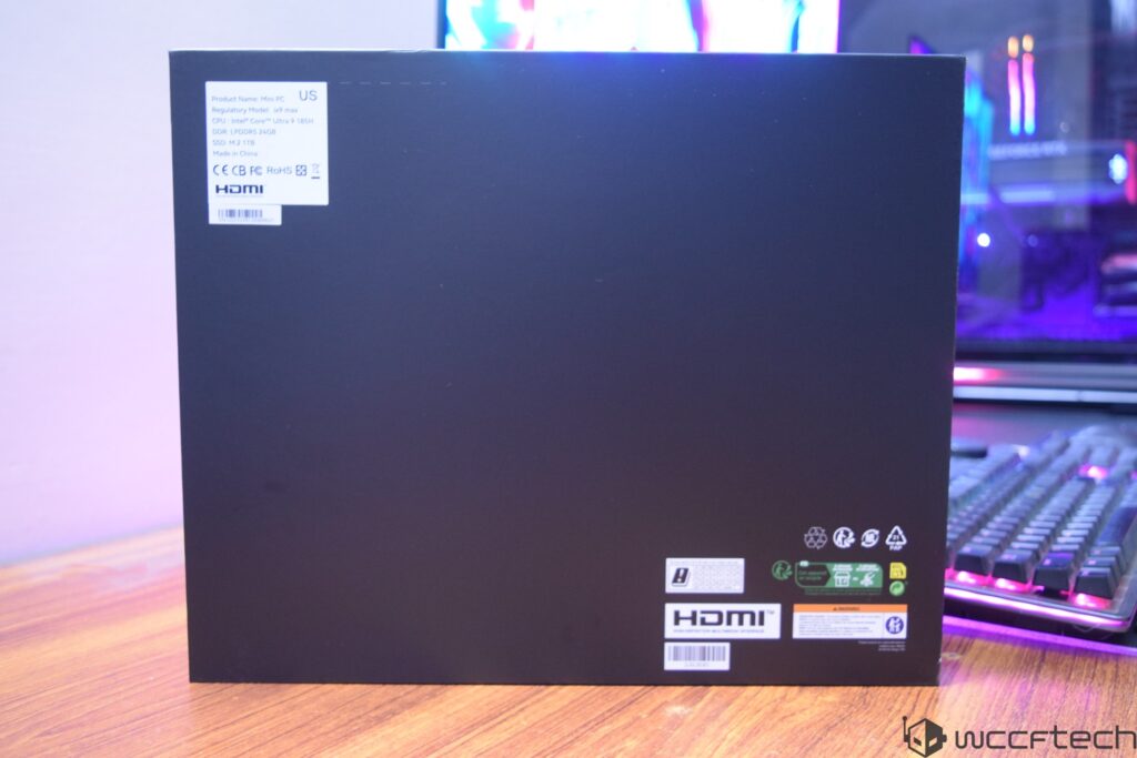 A black box labeled as Mini PC with specifications including Intel Core Ultra 9 185H and DDR4 LPDDR5 24GB stands on a wooden