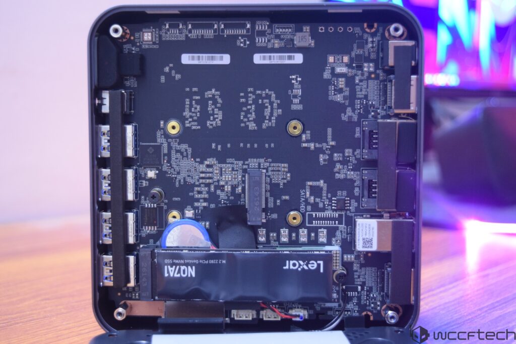 An open mini PC case reveals a Lexar M.2 2280 PCIe Gen4x4 NVMe SSD installed on the motherboard, with multiple USB ports visi